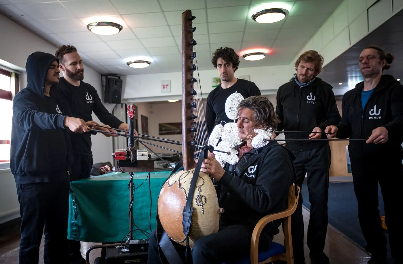 Stefan Charisius playing the kora while Dundu's puppeteers bring Baby Dundu to life beside him in rehearsal.