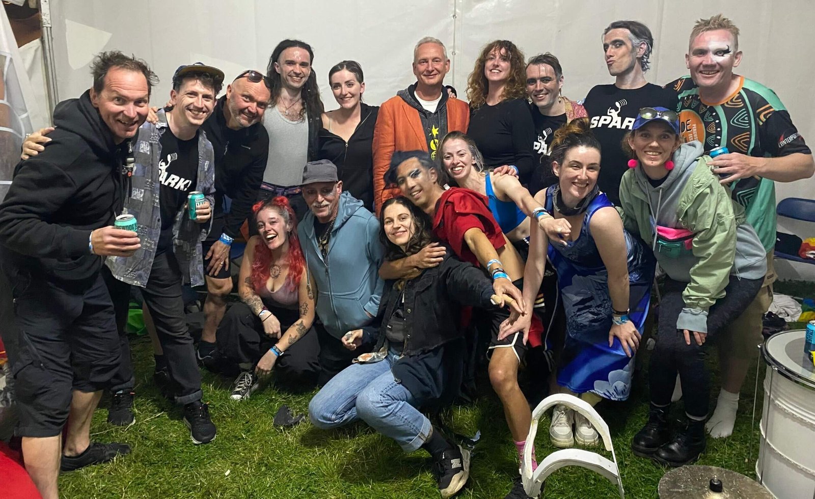 A big backstage group photo of the Spark! team celebrating after a show